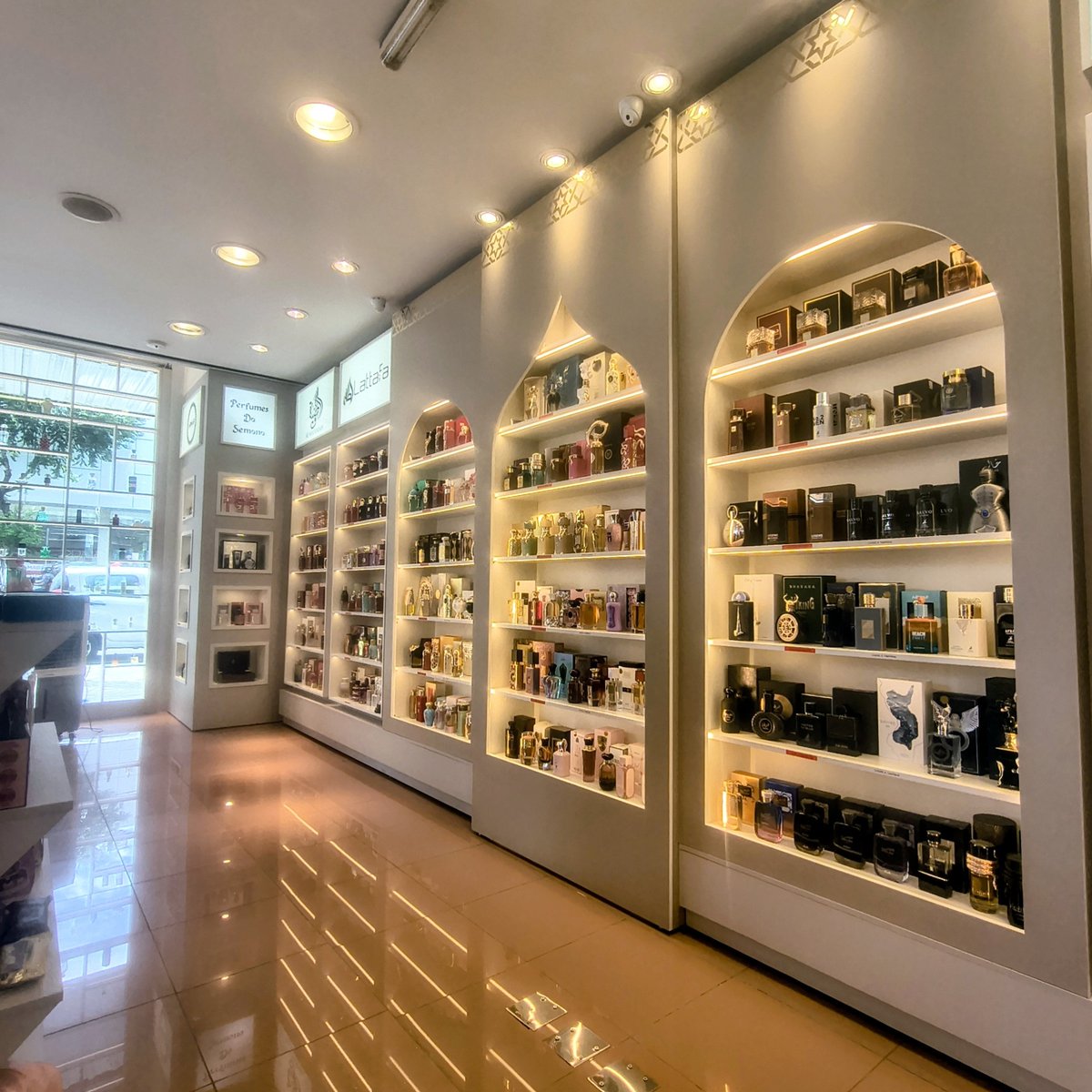 Arcos árabes com prateleiras iluminadas de perfumes